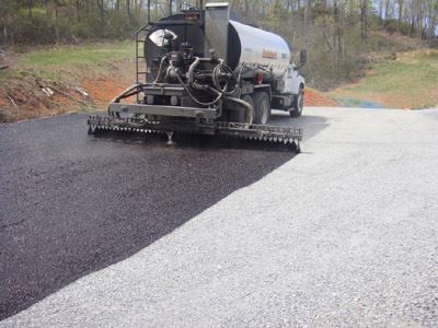 A truck applies sealcoat with flush coat.